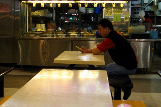 Man using his mobile phone at a food court